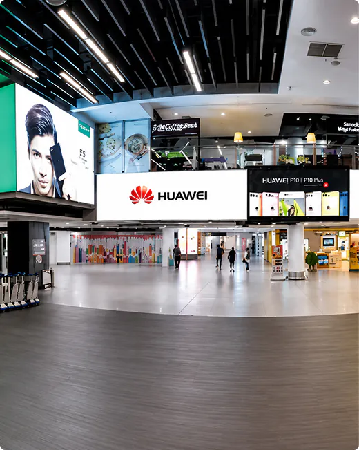 Retail digital screens with Huawei ads in a shopping mall concourse