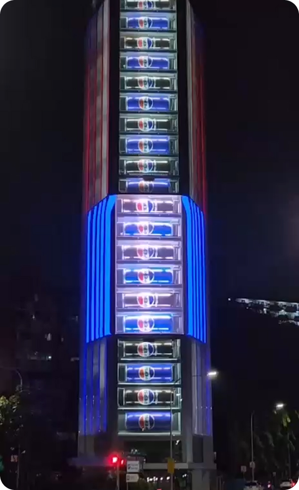 Vertical LED screen lighting up a high-rise tower at night